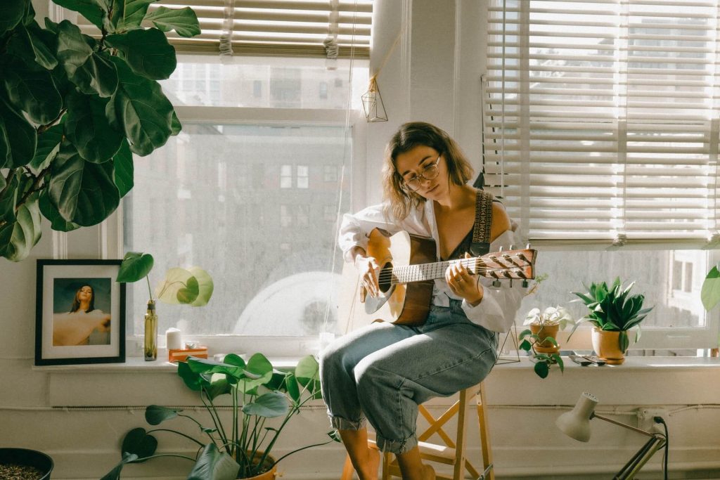 Girl playing guitar in the sunlight