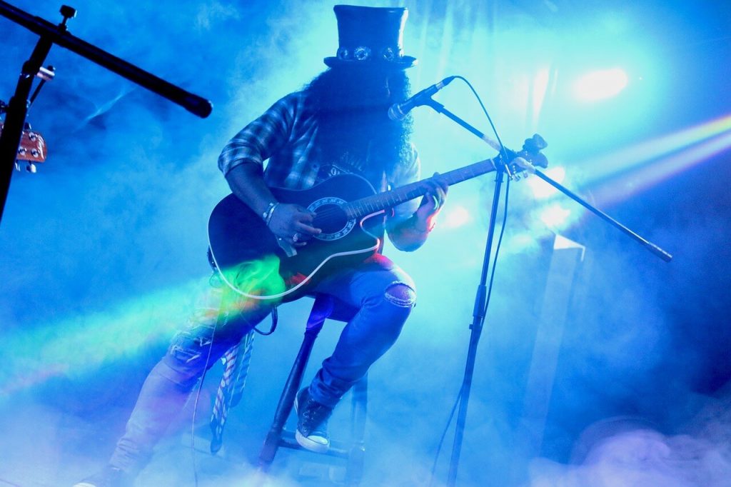 Slash plays a half-volume guitar in a performance