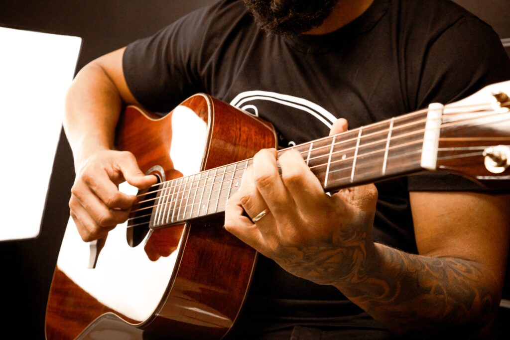 guy practicing with an acoustic-electric guitar